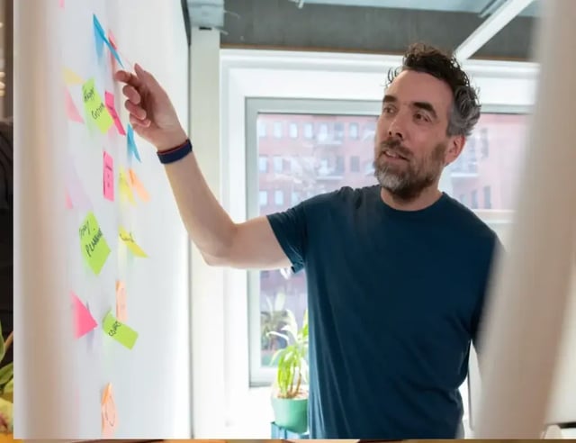 Collega wijst naar post-its en legt uit